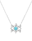 The Small White Gold Evil Eye Necklace by Nijma M Fine Jewelry features a central turquoise gemstone, triangular accents with clear stones, and is set on a delicate chain.