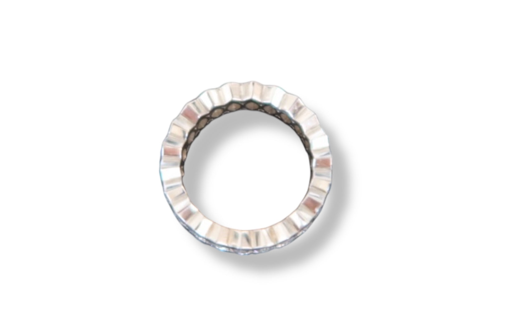 A silver-toned Marquise Diamond Eternity Ring by Nijma M Fine Jewelry, with a wavy, ridged edge, is shown from above on a white background, casting a subtle shadow—evoking the elegance of customizable 18K white gold designs.