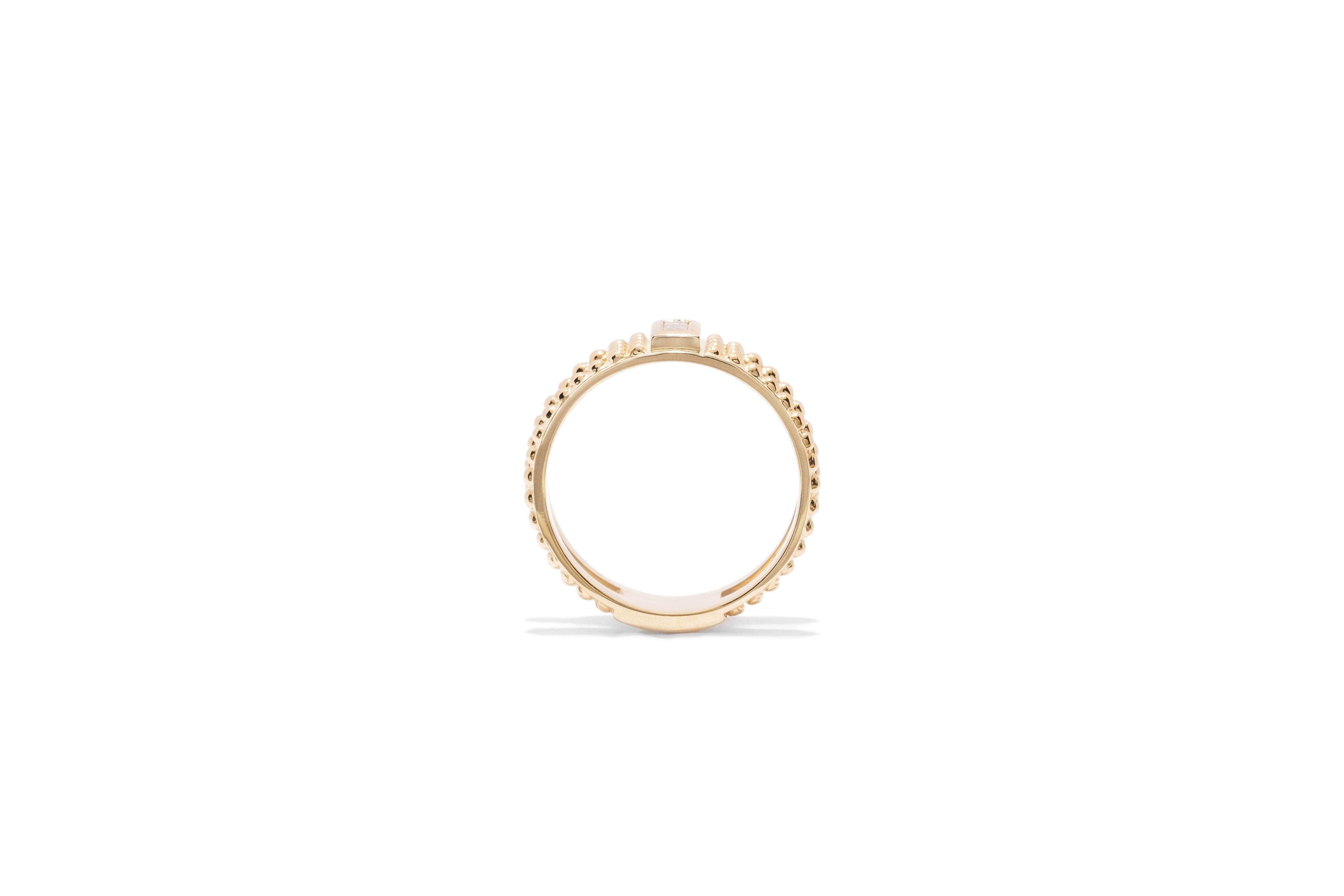 yellow gold single baguette diamond ring with gold bead detail and cutouts